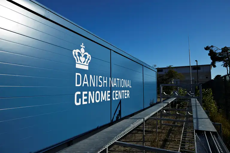 Blå container med hvidt NGC logo på siden, billedet er taget så hele længden af containeren ses..